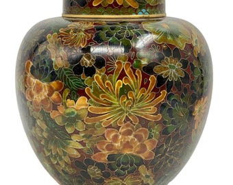 May include: A cloisonné jar with a lid, decorated with a floral pattern in shades of green, red, gold, and black.