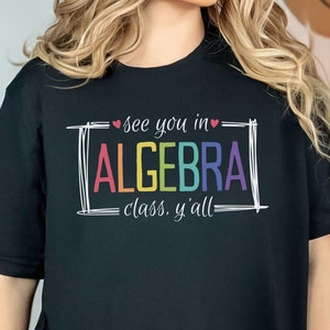 May include: Black t-shirt with a rainbow graphic that says "see you in ALGEBRA class, y'all".