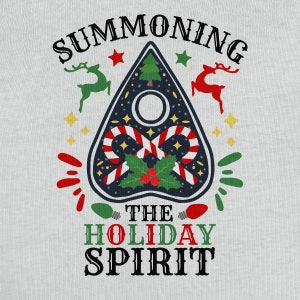 Pode incluir: Uma camiseta branca com um design de prancha Ouija preto e azul com bast&otilde;es de caramelo vermelho e branco, azevinho e bagas vermelhas. O texto "Summoning the Holiday Spirit" est&aacute; impresso em preto.