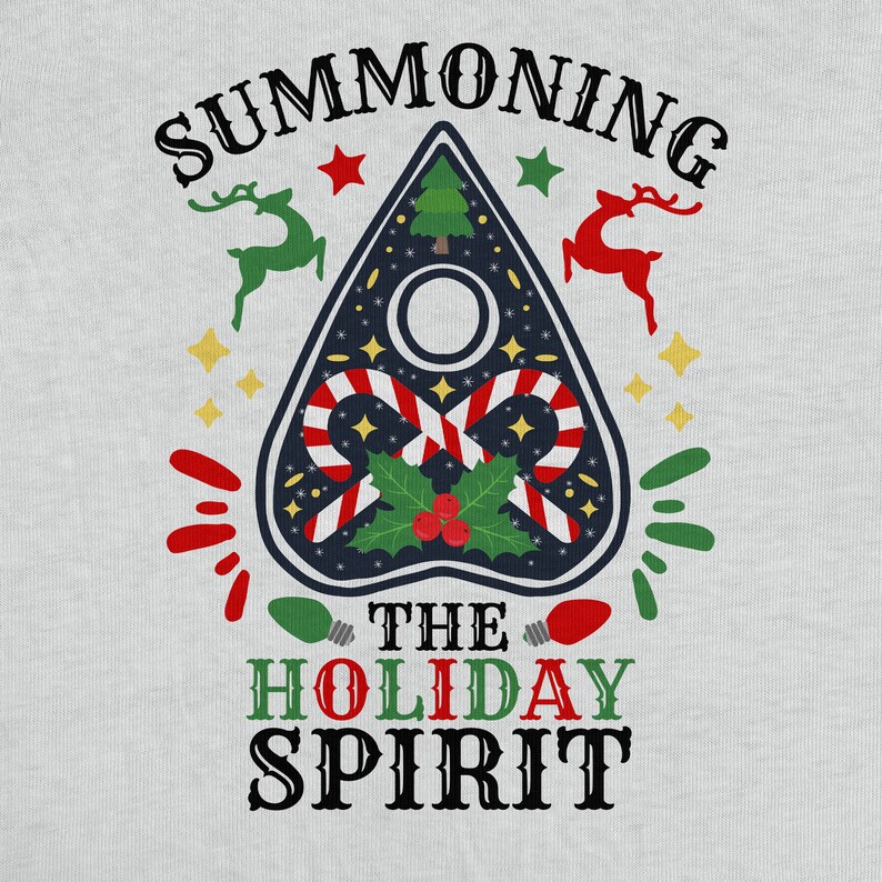 Pode incluir: Uma camiseta branca com um design de prancha Ouija preto e azul com bast&otilde;es de caramelo vermelho e branco, azevinho e bagas vermelhas. O texto "Summoning the Holiday Spirit" est&aacute; impresso em preto.