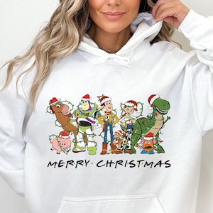 Pu&ograve; includere: Felpa bianca con una grafica natalizia dei personaggi di Toy Story che indossano cappelli di Babbo Natale e sono circondati da luci natalizie. Il testo "Merry Christmas" &egrave; stampato sotto la grafica.