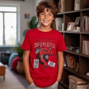 May include: A red t-shirt with a graphic of Spider-Man from a comic book cover. The text on the shirt reads "The Amazing Spider-Man".