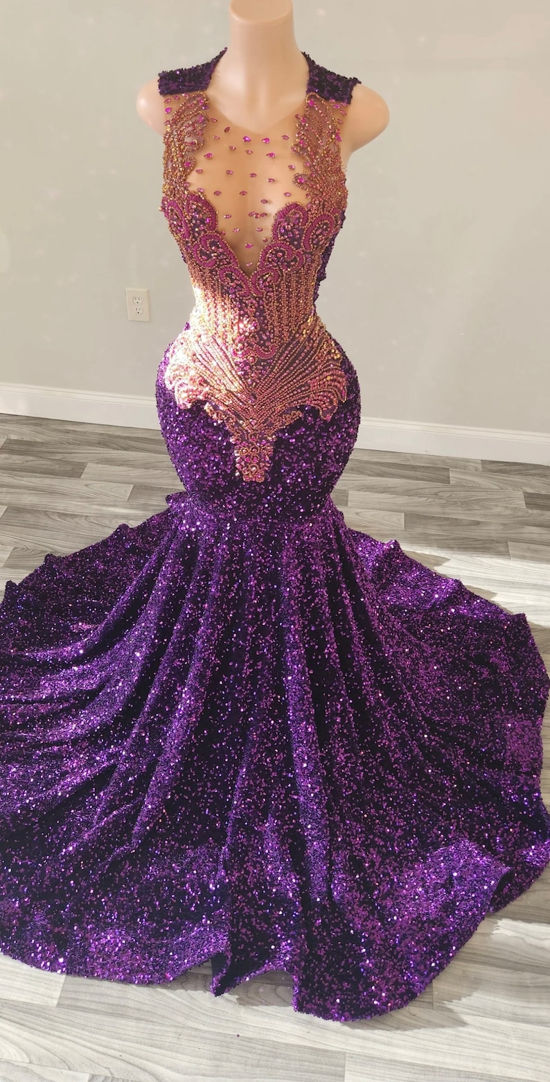 Puede incluir: Un vestido de sirena de lentejuelas moradas con un corpi&ntilde;o de cuentas doradas y moradas. El corpi&ntilde;o presenta un escote transparente y un dise&ntilde;o en V pronunciado.
