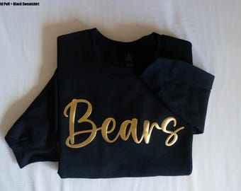 以下が含まれることがあります： 黒いスウェットシャツに、金色のパフ文字で「Bears」と書かれています。