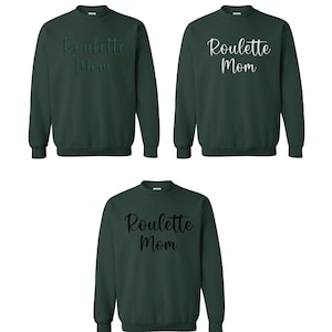 May include: Three dark green sweatshirts with the text "Roulette Mom" in different fonts. The sweatshirts are long-sleeved and have a crew neck. The text is in a cursive style on two of the sweatshirts and a block style on the other.