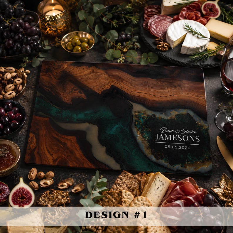 A rectangular wooden serving board featuring a dark brown wood grain and a central river-like inlay of swirling teal and black resin. The board is personalized with the white text Brian & Olivia JAMESONS and the date 05.05.2026.
