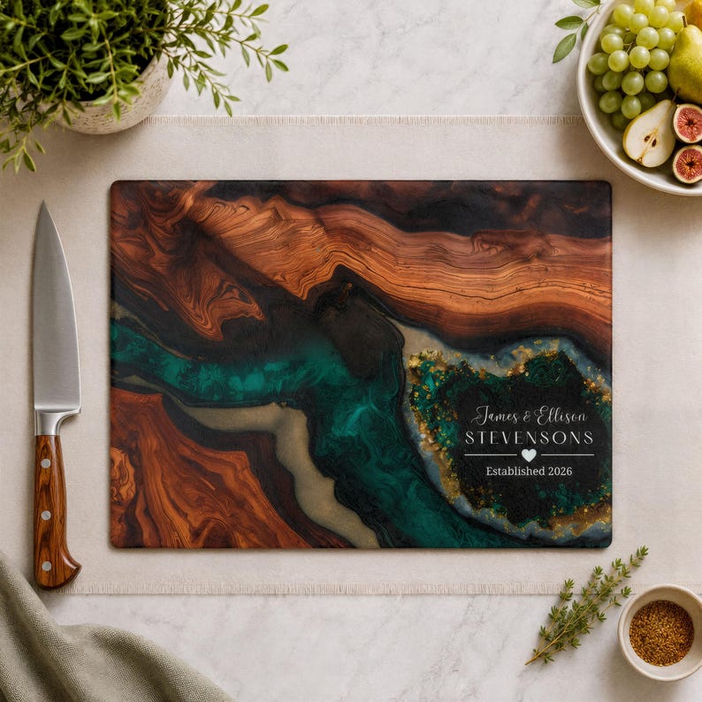 Personalized tempered glass cutting board with faux wood grain, teal geode resin-style design, gold accents, and custom couple name text.
