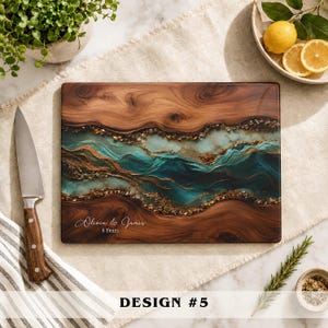 May include: A rectangular wooden cutting board featuring a central resin inlay with swirling teal, blue, and gold metallic accents. The board is engraved with the text Olivia & James 8 Years. A stainless steel knife with a wooden handle sits nearby.