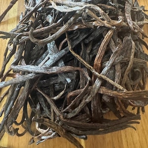 May include: A pile of dried vanilla beans, a popular spice used in baking and cooking.