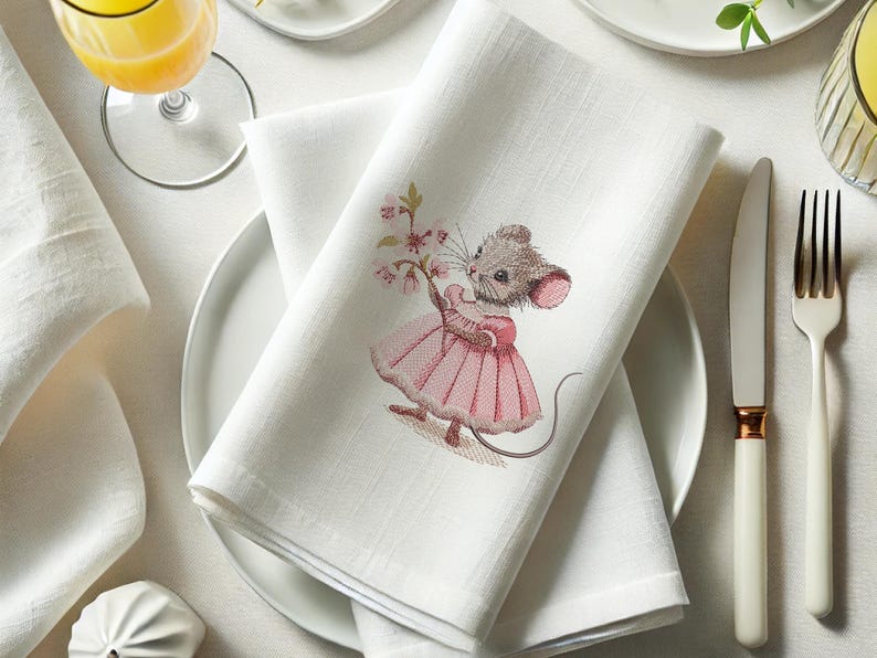 May include: White linen napkin with embroidered image of a mouse wearing a pink dress and holding a bouquet of pink flowers.