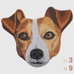 Puede incluir: Bordado de la cara de un perro Jack Russell Terrier con pelaje marrón y blanco, ojos marrones y nariz negra. La imagen muestra la cabeza y las orejas del perro. El texto indica 3 tamaños y 9 colores disponibles.