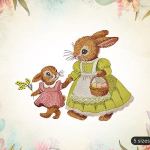 Può includere: Due coniglietti ricamati, uno con un cestino di uova di Pasqua, l'altro con un mazzo di fiori. I coniglietti indossano vestiti e hanno la pelliccia marrone. Lo sfondo è un motivo floreale.