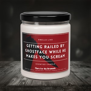 May include: White candle jar with a red label that reads "Smells Like Getting Railed By Ghostface While He Makes You Scream". The label also says "Scented Candle" and "Flare for the Dramatic".