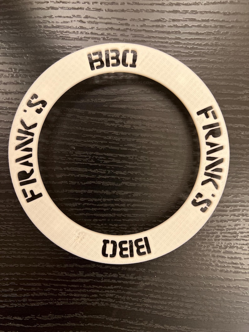 May include: White plastic ring with the words "Frank's" and "BIBO" printed in black on the outside of the ring.