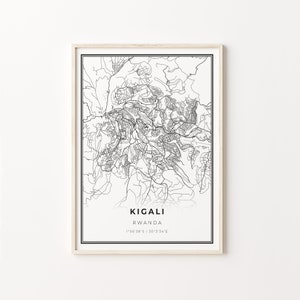 May include: A black and white line art map of Kigali, Rwanda, with the city name and coordinates printed below the map. The map is framed in a light wood frame.