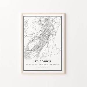 May include: Black and white line art map print of St. John's, Newfoundland and Labrador, Canada. The map includes the city's streets and waterways. The text "ST. JOHN'S", "NEWFOUNDLAND AND LABRADOR", and "47°33′41″N 52°42′45°W" is printed below the map.