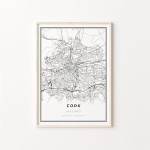 Puede incluir: Un mapa en blanco y negro enmarcado de Cork, Irlanda. El mapa detalla las calles y vías fluviales de la ciudad. El nombre de la ciudad y las coordenadas están impresos en la parte inferior. El marco es de color madera clara.