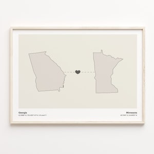 May include: A minimalist print featuring the outlines of Georgia and Minnesota with a small black heart in the middle, connected by a dashed line. The states' names and coordinates are listed below the outlines.