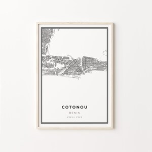 May include: Black and white map print of Cotonou, Benin. The map shows the city's streets and landmarks. The text below the map reads "Cotonou, Benin, 6°28'N | 2°36'E".