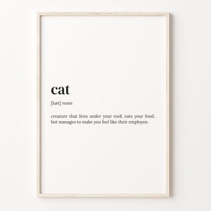 Peut inclure: Une impression murale d'art imprimable en noir et blanc avec une définition humoristique du mot "chat". La définition se lit comme suit : "créature qui vit sous votre toit, mange votre nourriture, mais parvient à vous faire sentir comme son employé."