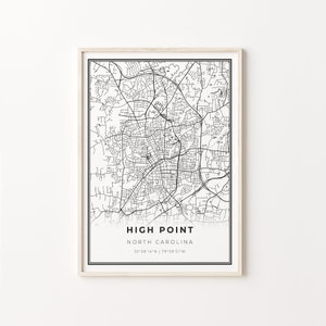 以下が含まれることがあります： ノースカロライナ州ハイポイントの白黒地図プリント。地図には市の通りとランドマークが表示されています。プリントは明るい木製のフレームで額装されています。