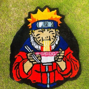 May include: A colourful rug featuring an anime character with orange hair, a red jacket, and blue trousers, eating ramen noodles from a bowl.
