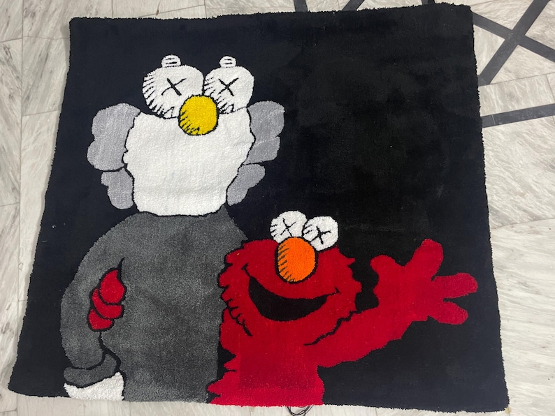 May include: A black and white rug featuring a grey and white cartoon character on the left and a red cartoon character on the right. Both cartoon characters are smiling.