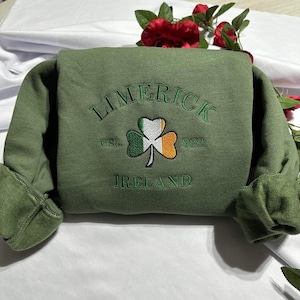 May include: Green sweatshirt with an embroidered shamrock and the text "LIMERICK est. 922 IRELAND".
