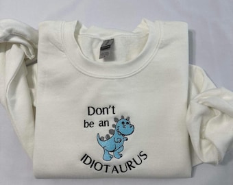 Felpa con ricamo "Non essere un idiota"; girocollo con ricamo "Dino divertente".