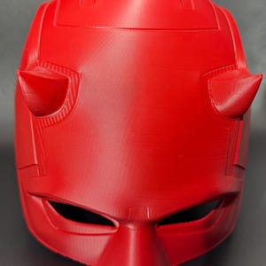 May include: A red plastic Daredevil mask with horns and eye holes.