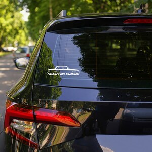 May include: A black car with a white sticker on the back window. The sticker features a white silhouette of a car and the text "Need for Swede".