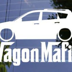 May include: White vinyl decal of a station wagon with the text "Wagon Mafia" underneath. The car graphic is a side profile, showing the wheels and windows. The decal is displayed on a window.