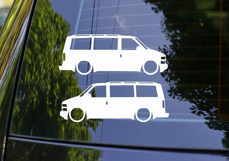 Może przedstawiać: Dwa białe naklejki winylowe z sylwetką furgonetki Chevrolet Express. Naklejki znajdują się na niebieskim oknie samochodu.
