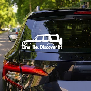 Peut inclure: Autocollant en vinyle blanc repr&eacute;sentant la silhouette d'un Land Rover Discovery avec le texte "One life, Discover it!" sur une voiture noire.