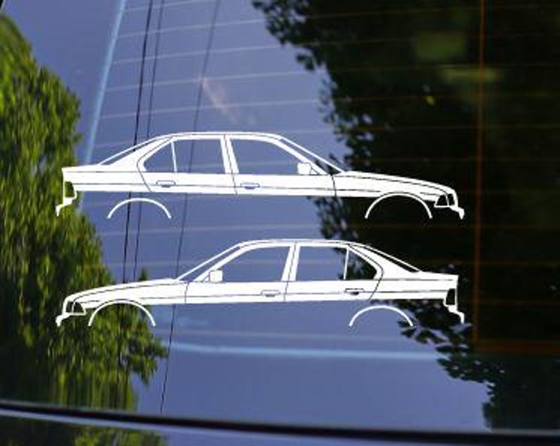 Pode incluir: Duas decalcomanias brancas para carro, cada uma representando um perfil lateral de um sedan. As decalcomanias s&atilde;o aplicadas em uma superf&iacute;cie escura e reflexiva, com uma &aacute;rvore verde desfocada ao fundo. O design do carro inclui detalhes das rodas e janelas.