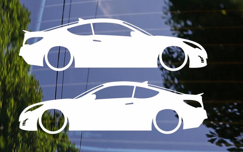 Puede incluir: Dos calcoman&iacute;as de coche de vinilo blanco, una encima de la otra, mostrando la silueta de un coche coup&eacute;. Las calcoman&iacute;as est&aacute;n sobre un fondo azul oscuro.