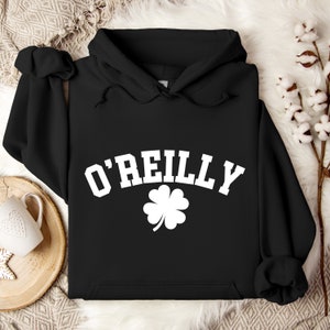 May include: Black hooded sweatshirt with a white shamrock and the text "O'Reilly" in a white arched font.
