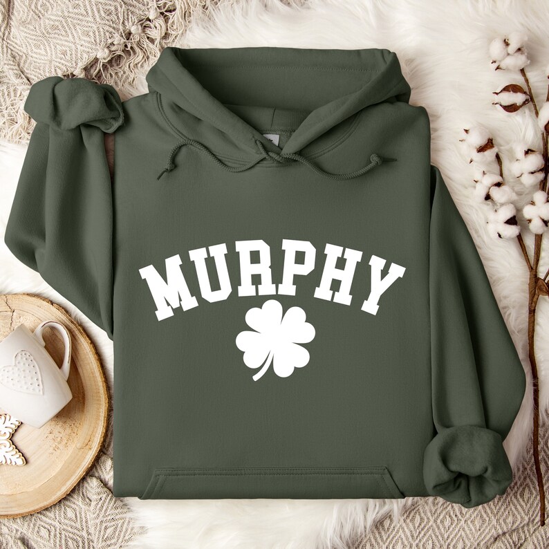 May include: A green hooded sweatshirt with the word "MURPHY" in white block letters and a white four-leaf clover.