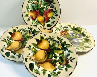 May include: A set of five decorative plates featuring a fruit design. The plates showcase a cream-colored background with illustrations of pears, apples, and grapes surrounded by green leaves. The rims have a brown and cream checkered pattern.