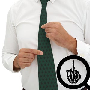 May include: Dark green tie with a repeating black middle finger graphic. The tie is being adjusted by a person wearing a white dress shirt. A magnifying glass shows a skeleton hand giving the middle finger.