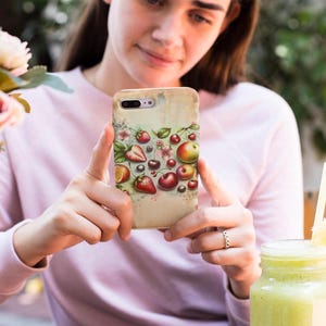 May include: A phone case with a watercolor design of various fruits and berries, including strawberries, cherries, apples, and blueberries. The case has a vintage aesthetic with a faded background.