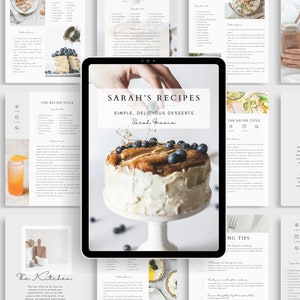 May include: A digital tablet displaying a recipe book cover with a photo of a cake topped with blueberries and the text "SARAH'S RECIPES SIMPLE, DELICIOUS DESSERTS Sarah Greene".