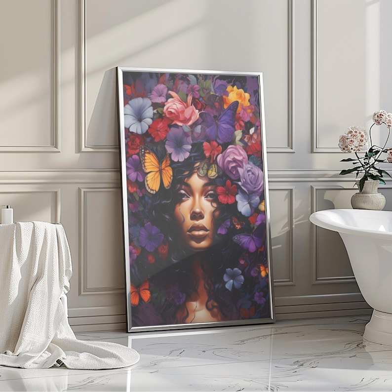 K&ouml;nnte beinhalten: Ein gerahmter Kunstdruck mit einem Frauenportr&auml;t mit einem Blumen- und Schmetterlingskranz. Das Kunstwerk zeigt eine Frau mit dunklem Haar und Haut, umgeben von bunten Blumen und Schmetterlingen in Lila, Rosa, Orange und Blau.