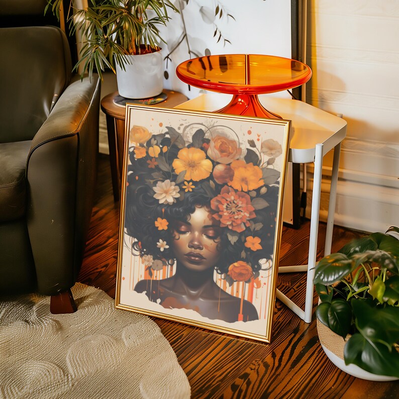Op de afbeelding: Een ingelijste print van een vrouw met een donkere huid en bruin haar. Haar haar is versierd met een kroon van oranje, gele en witte bloemen. De achtergrond is lichtbeige met oranje en gele verfspatten.
