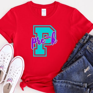 May include: Red t-shirt with a turquoise blue letter "P" with a purple outline and the text "pre-k" in purple.
