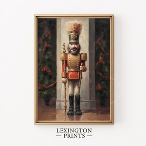 Op de afbeelding: Een vintage-achtig schilderij van een houten speelgoed soldaat die voor een witte pilaar staat. De soldaat draagt een rood en gouden uniform met een zwarte hoed en een witte pluim. De soldaat houdt een geweer in de ene hand en een staf in de andere. Het schilderij is tegen een achtergrond van groene bomen en rode linten.