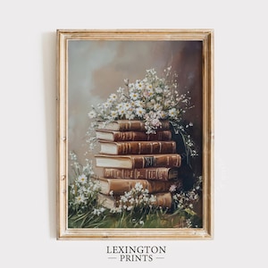 May include: A framed vintage-style print featuring a stack of antique books with brown leather covers. White daisies and greenery cascade over the books. The print has a gold frame and the text "LEXINGTON PRINTS" at the bottom.