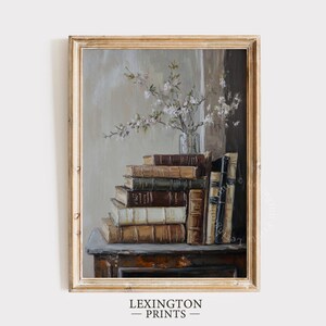 May include: A painting of a stack of antique books with leather bindings, a vase of white blossoms, and a wooden table. The books are arranged in a staggered stack, with the tallest book on the left and the shortest book on the right. The vase is clear glass and contains a bouquet of white flowers with green leaves. The table is a dark brown wood and has a simple, rectangular shape.