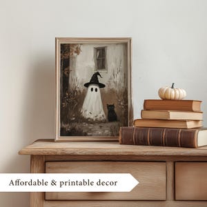 Vintage Halloween wall art print of a cute white ghost dressed as a witch in a witch hat next to his cute black cat in a fall scene. The Halloween painting features moody fall colors of black, white and brown hues along with intricate brushwork. The artwork embodies themes of vintage Halloween wall decor, dark farmhouse decor, dark cottagecore decor, gothic decor, and halloween wall decor. The shop name Lexington Prints is written below