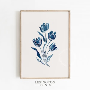 Puede incluir: Una impresión enmarcada con una ilustración de acuarela de tulipanes azules. La obra floral se encuentra sobre un fondo crema, con el texto "LEXINGTON - PRINTS" en la parte inferior. El marco es de color marrón claro.
